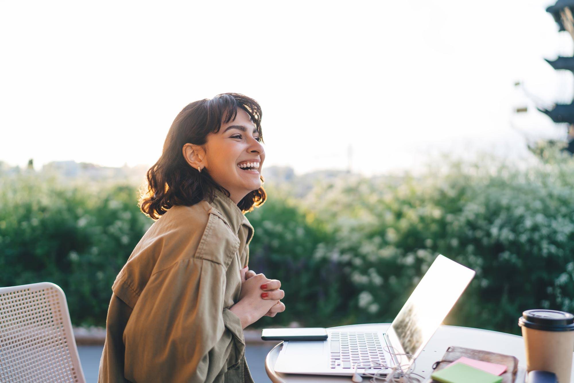 Side,View,Of,Young,Brunette,Smiling,Happily,While,Sitting,At